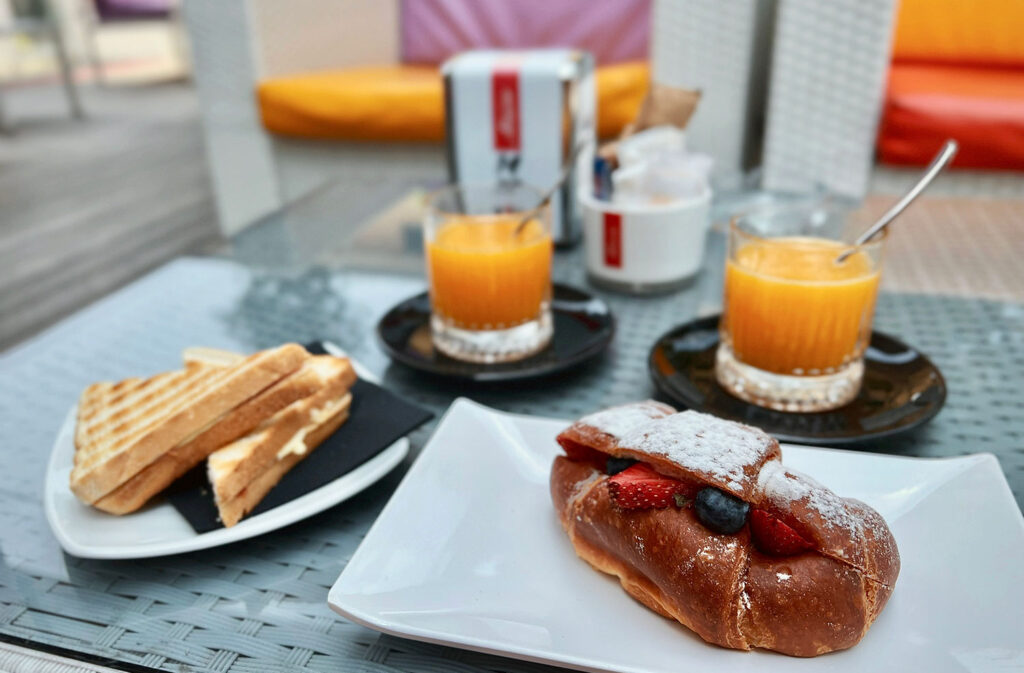 Toast, orange juice, and a croissant, typical Italian breakfast.