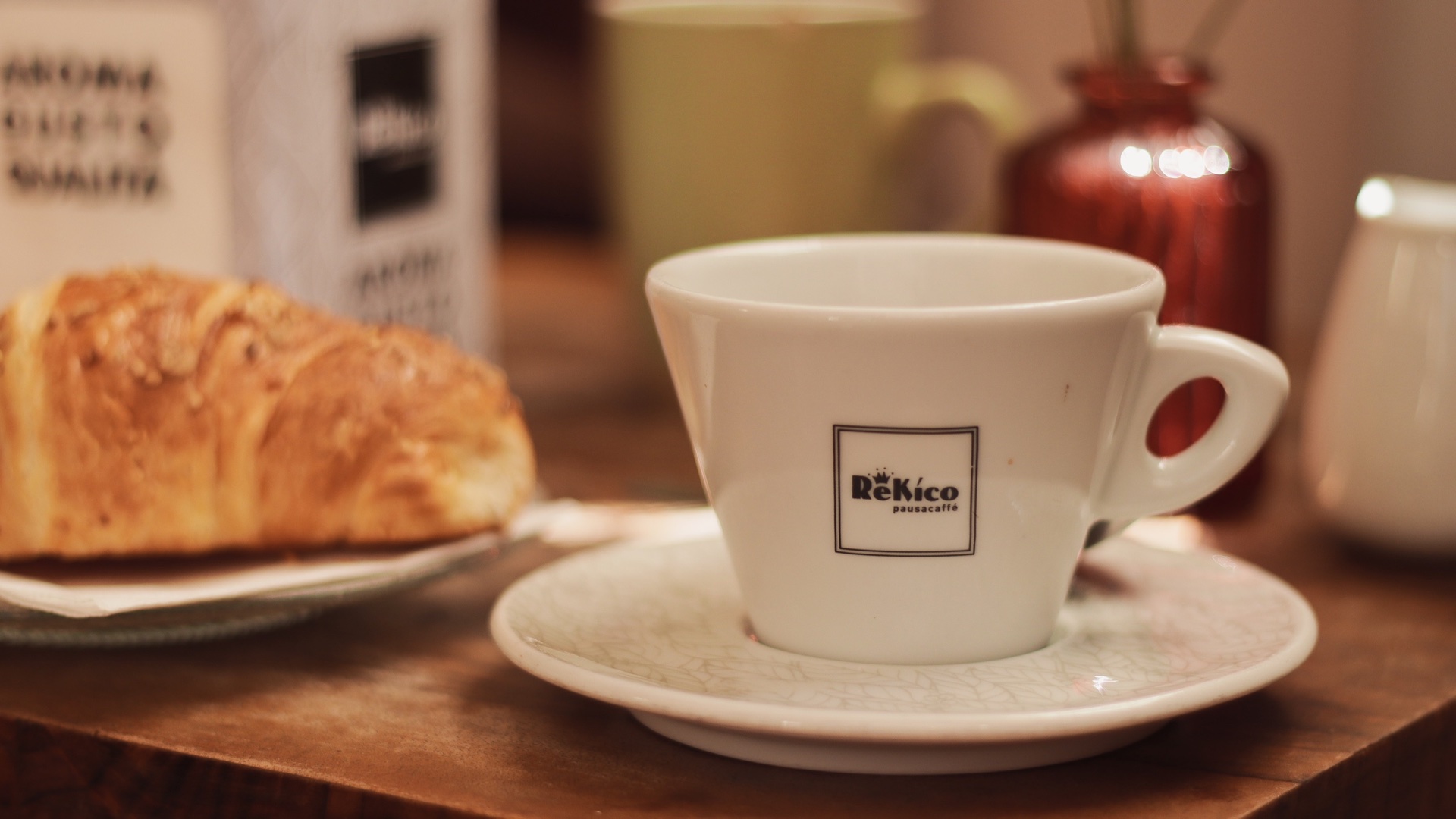 Espresso cup and croissant on a warm cafe table, ideal for Italian coffee shop and breakfast travel content