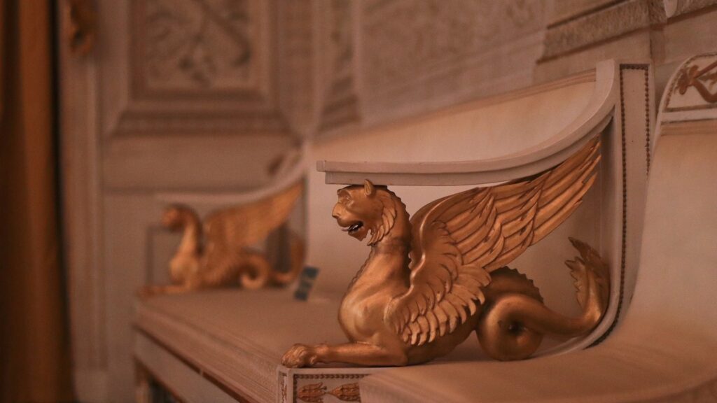 Golden winged lion sculpture supporting a decorative shelf in a refined historic Italian interior