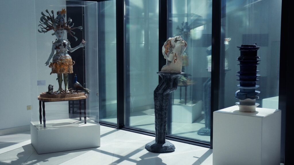 Contemporary ceramic sculptures displayed in glass cases inside the International Museum of Ceramics in Faenza