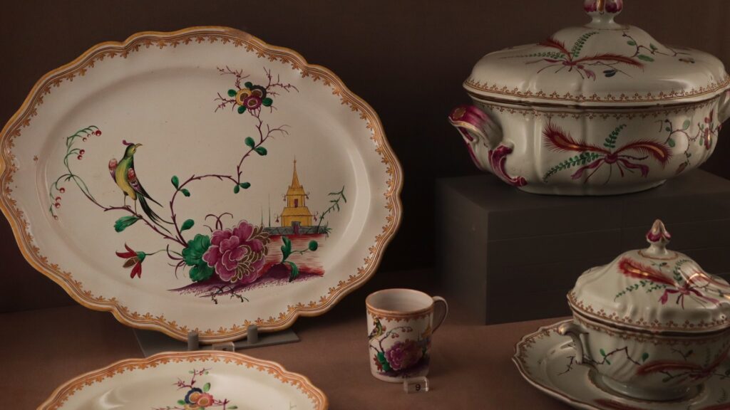 Antique porcelain tableware with floral and bird motifs displayed in International Museum of Ceramics in Faenza