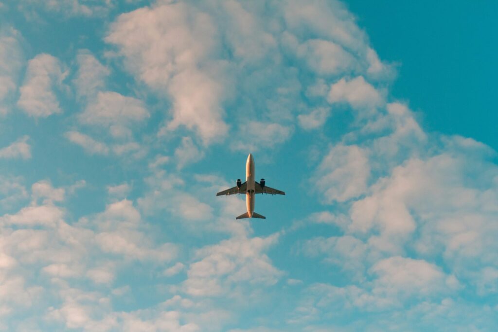 Airplane flying through blue sky for booking flights to Emilia-Romagna Italy